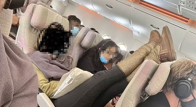 Uçakta şoke edici görüntü: Ayaklarını önündeki yolcunun kafasına uzatan kadına tepki yağdı