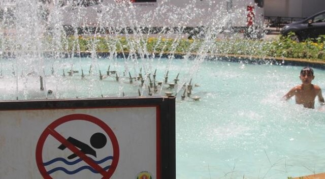 Sıcaktan bunalan çocuklar kendini süs havuzuna attı