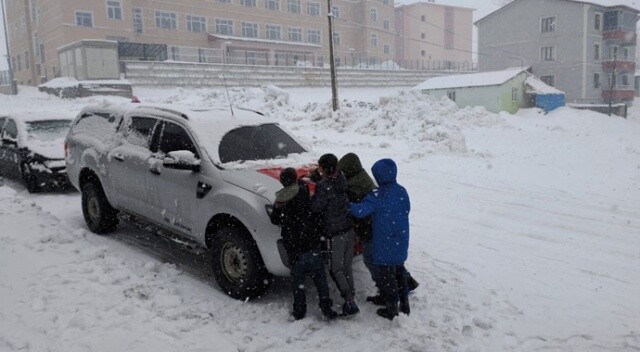 Çocuklar, bir aracın önündeki Türk bayrağının üzerindeki karı temizledi