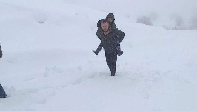 Yürekleri ısıtan görüntü: Karda yürüyemeyen öğrencisini sırtına alıp götürdü
