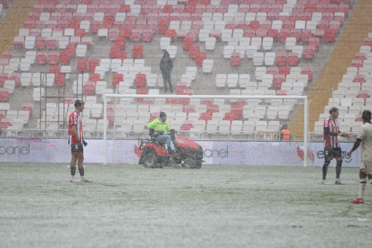 Karşılaşma sırasında etkili olan kar yağışı sonrası görevliler saha çizgisini temizledi