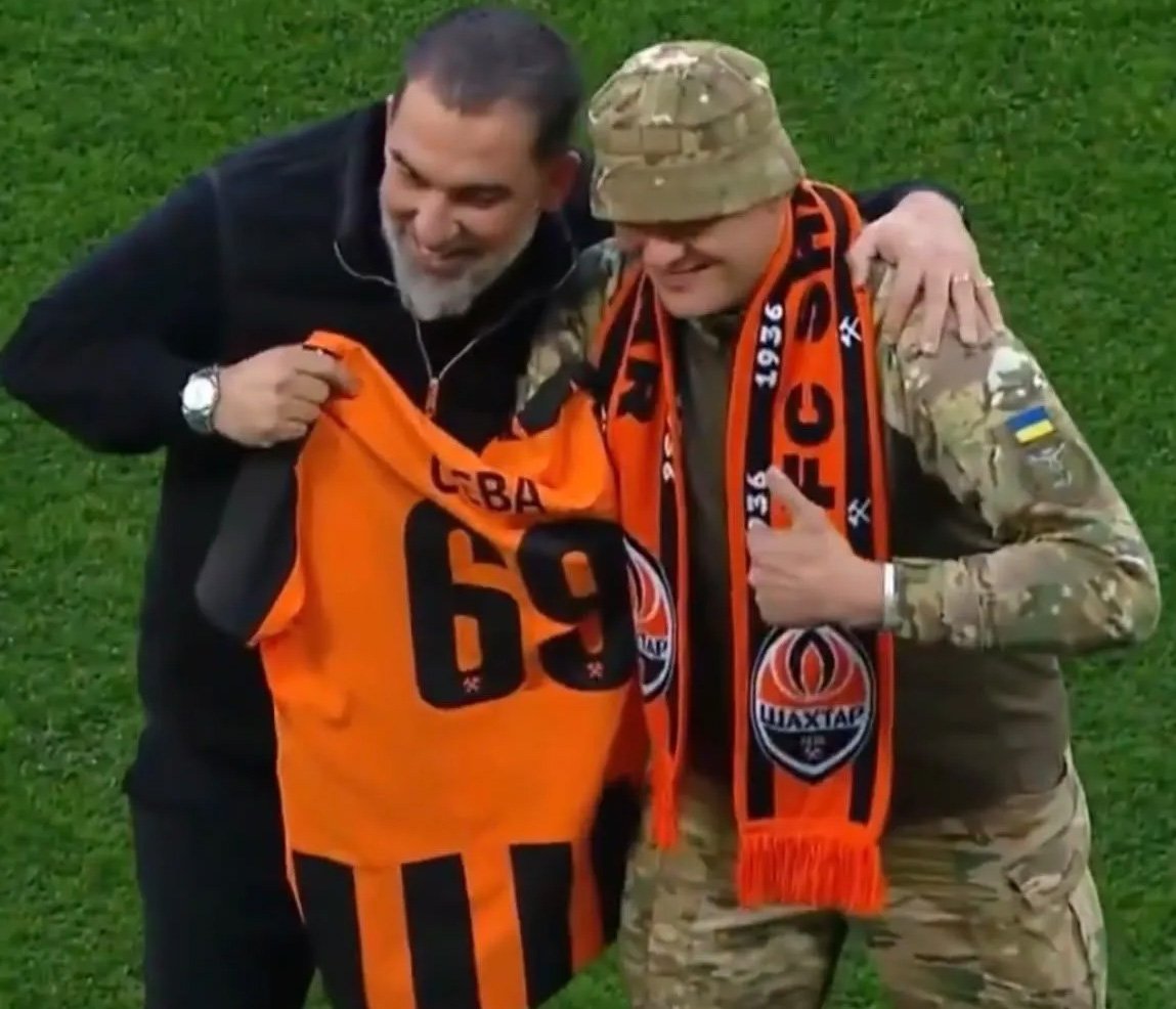 Arda Turan ile Ukraynalı asker, sahada basın mensuplarına poz verdi.