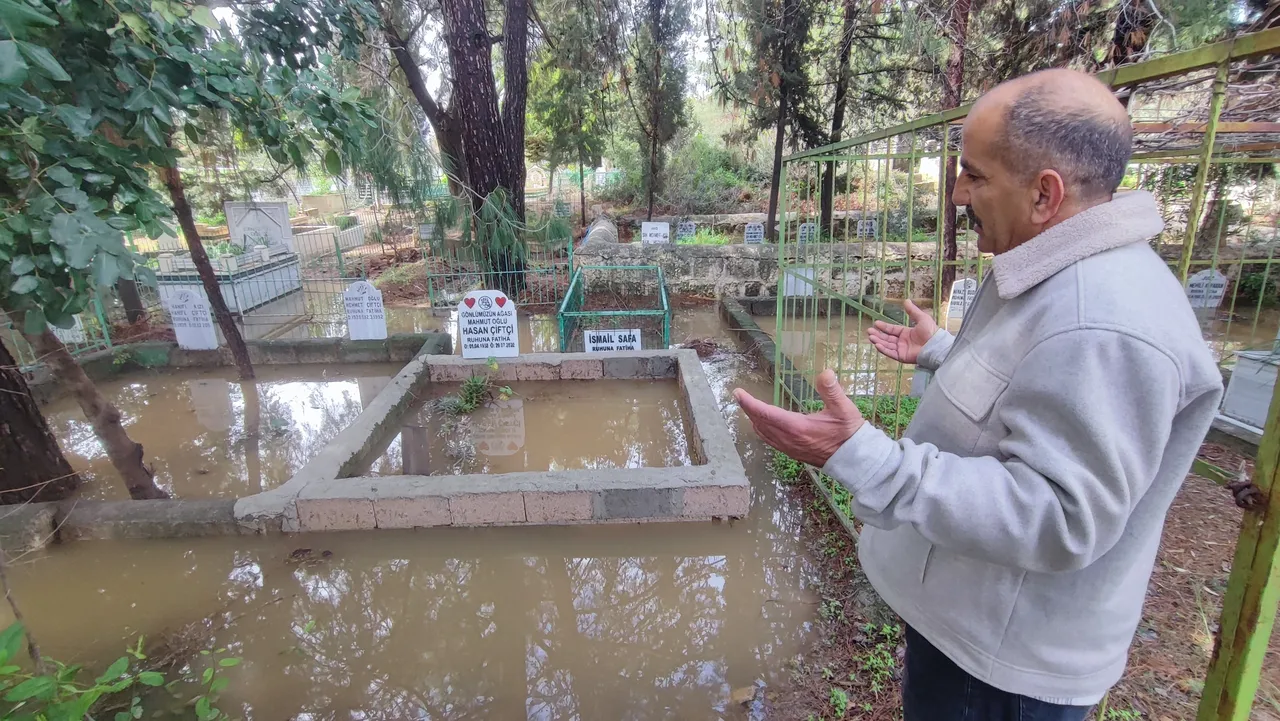 Sağanak yağış mezarlığı göle çevirdi! Poşet geçirip girdiler