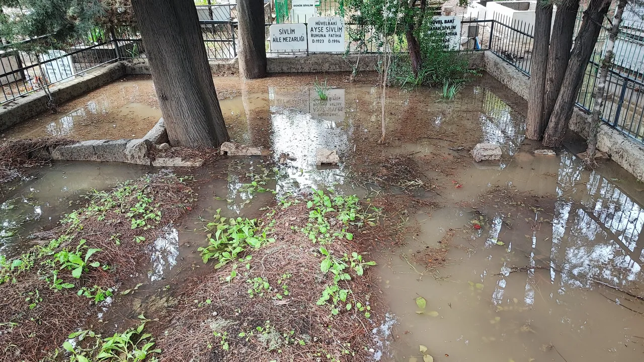 Sağanak yağış mezarlığı göle çevirdi! Poşet geçirip girdiler
