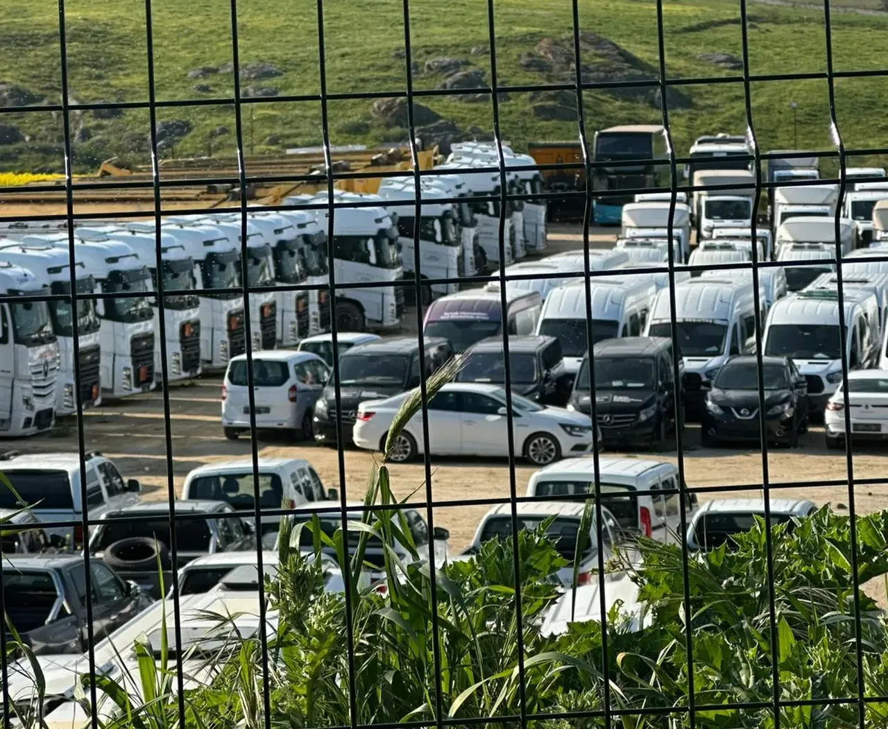 Yüzlerce minibüs, otobüs, çöp ve hafriyat kamyonu, dikenli tellerle çevrili alanda çürümeye terk           edilmiş hâlde  görüntülendi.