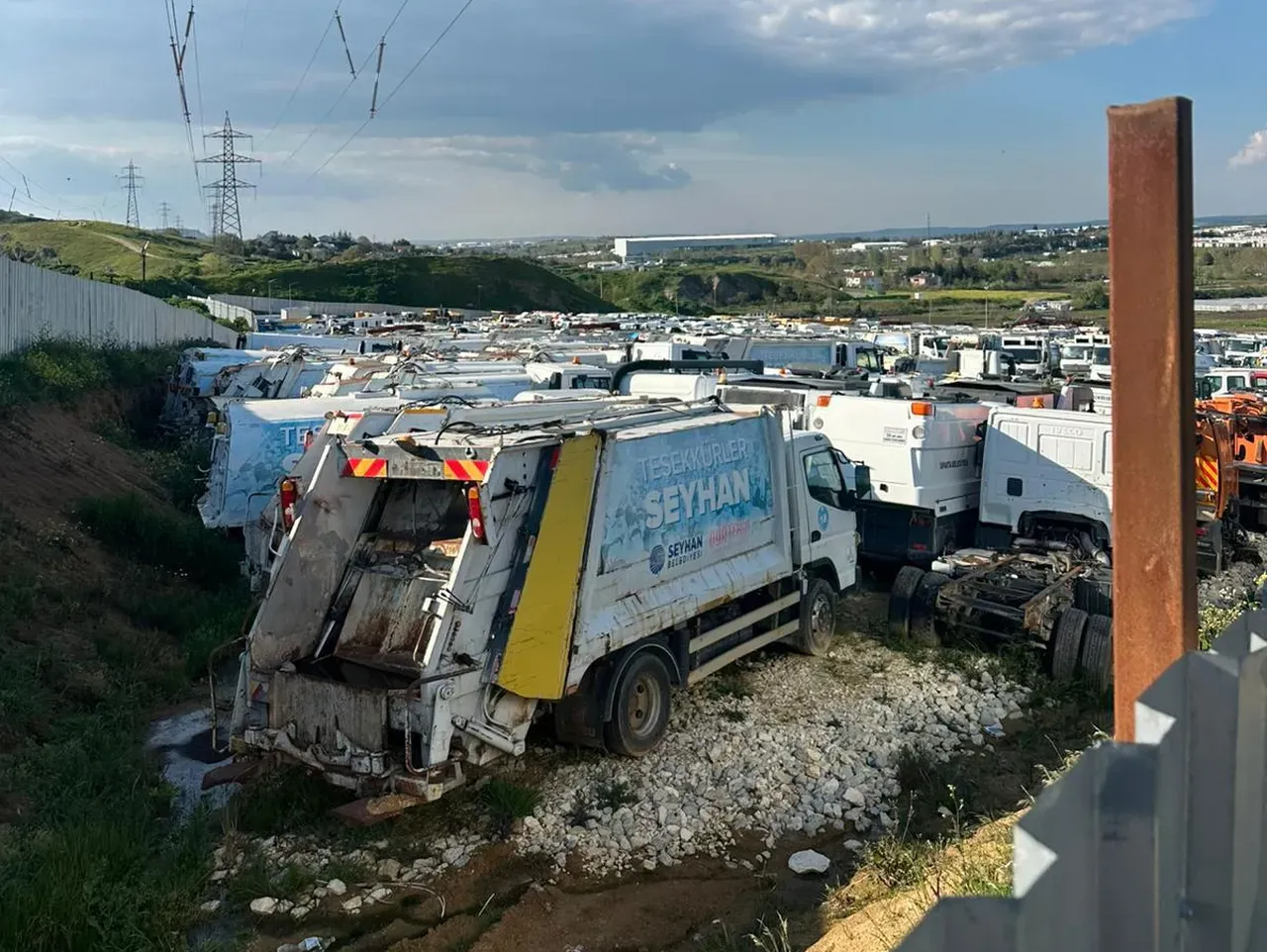 Yüzlerce minibüs, otobüs, çöp ve hafriyat kamyonu, dikenli tellerle çevrili alanda çürümeye terk           edilmiş hâlde  görüntülendi.