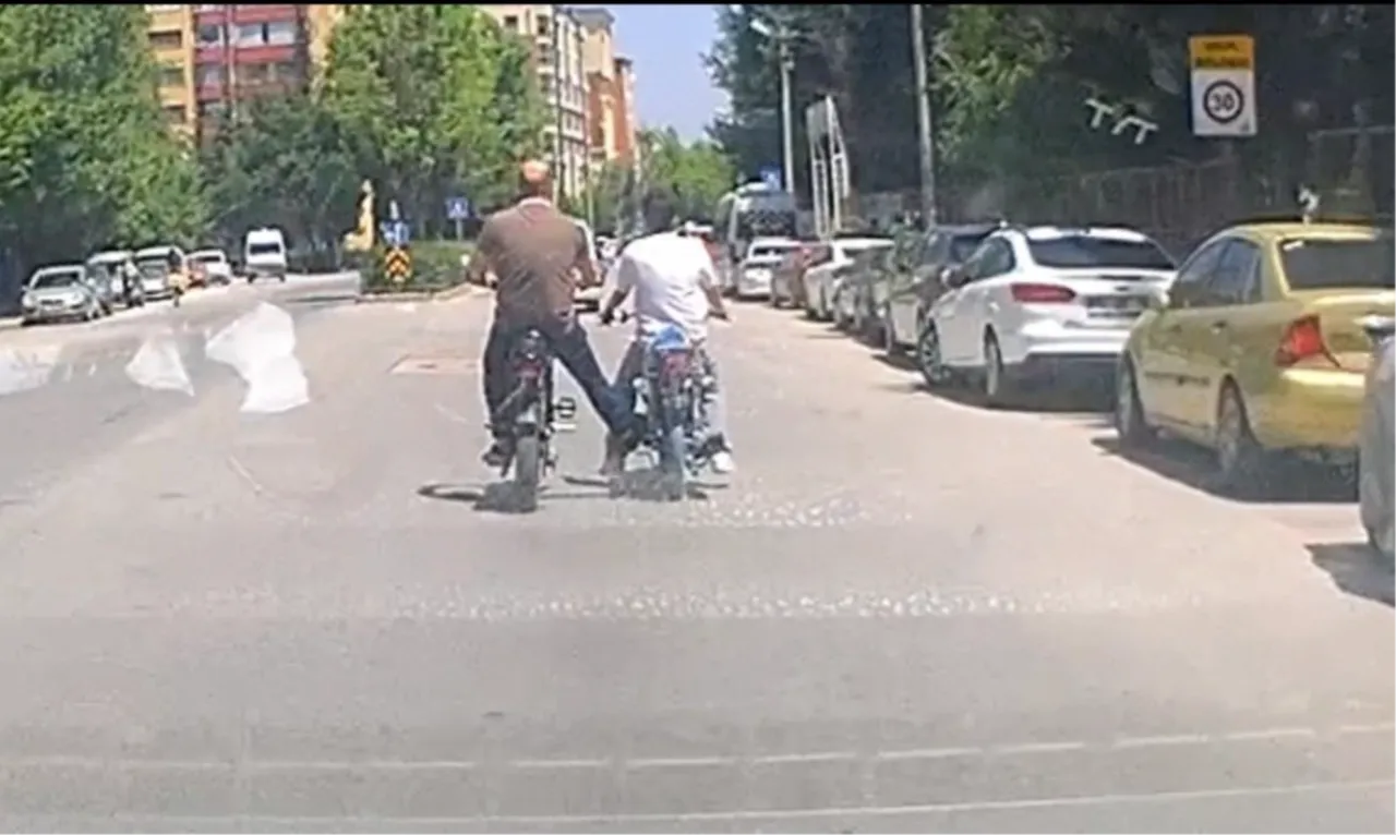 Trafikte akılalmaz görüntü! Ayağıyla motosikleti iterek ilerleyen bisikletli kamerada
