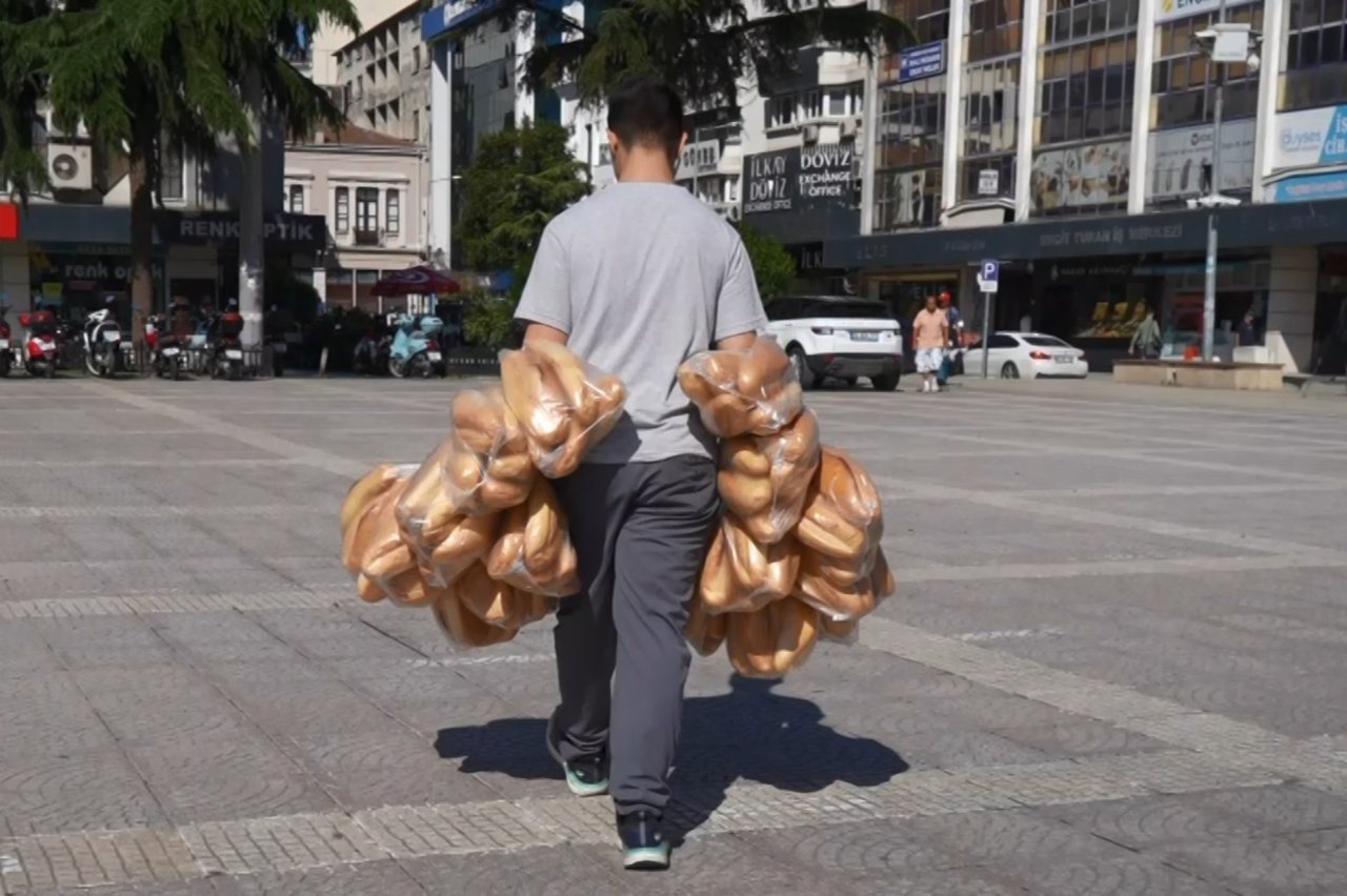 Böyle rekor görülmedi! Tek seferde iki kolunda 100 ekmek taşıyor, gören bir daha bakıyor