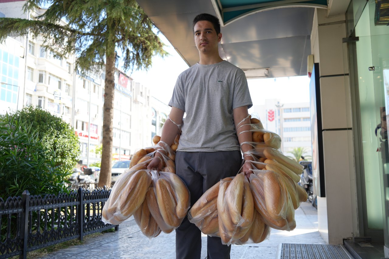 Böyle rekor görülmedi! Tek seferde iki kolunda 100 ekmek taşıyor, gören bir daha bakıyor