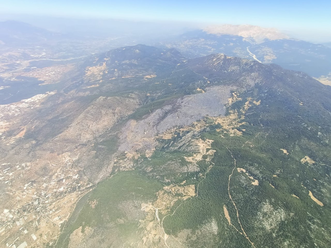 Antalya'nın Kaş ilçesinde çıkan yangında zarar gören ormanlık alan havadan görüntülendi.