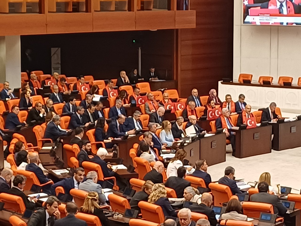 İYİ Parti grubu milletvekilleri yakalarına Türk bayraklarıyla oturdu.