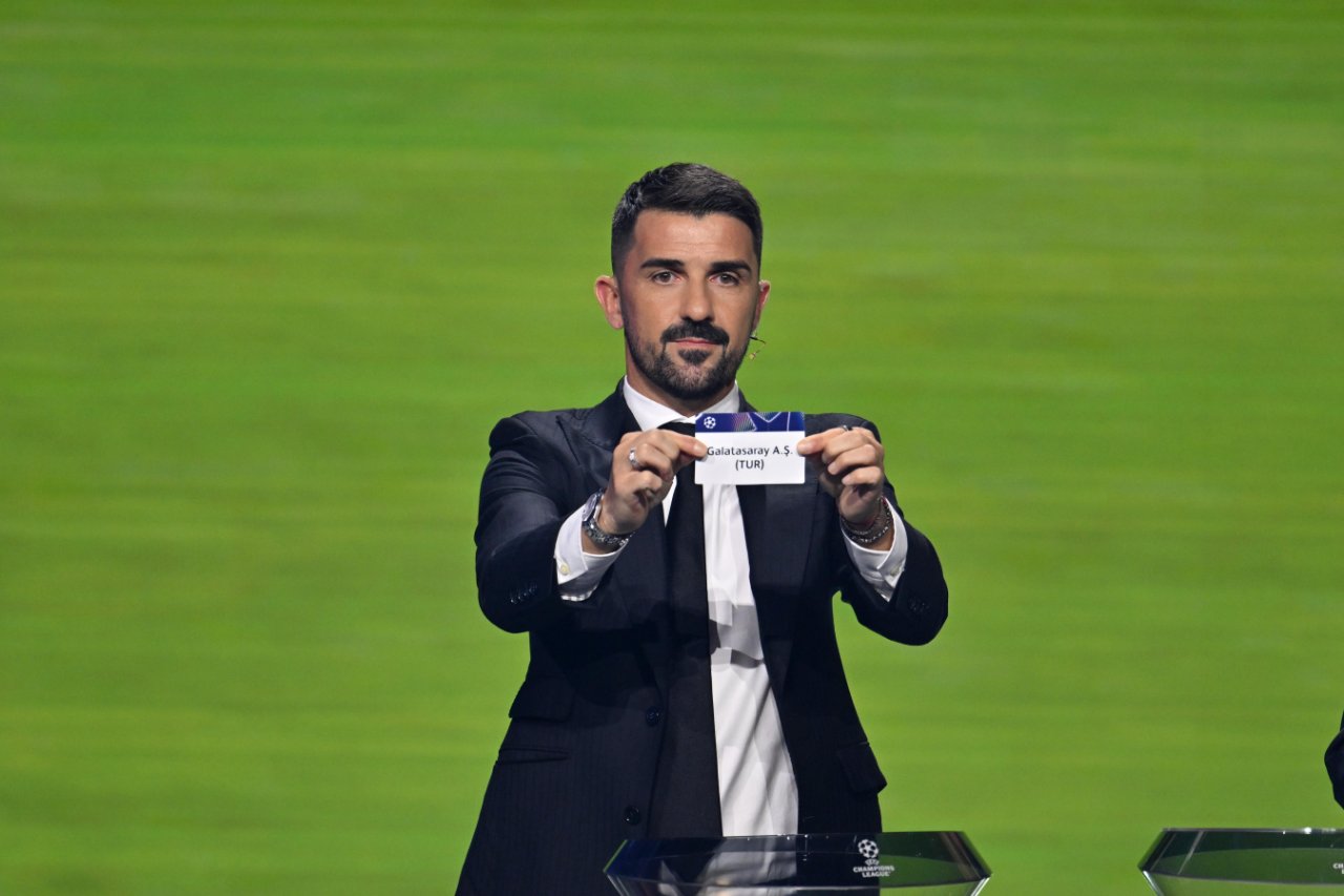 Kura çekimini gerçekleştiren eski İspanyol futbolcu David Villa Galatasaray A.Ş. (TUR) yazılı kağıdı gösterdi.
