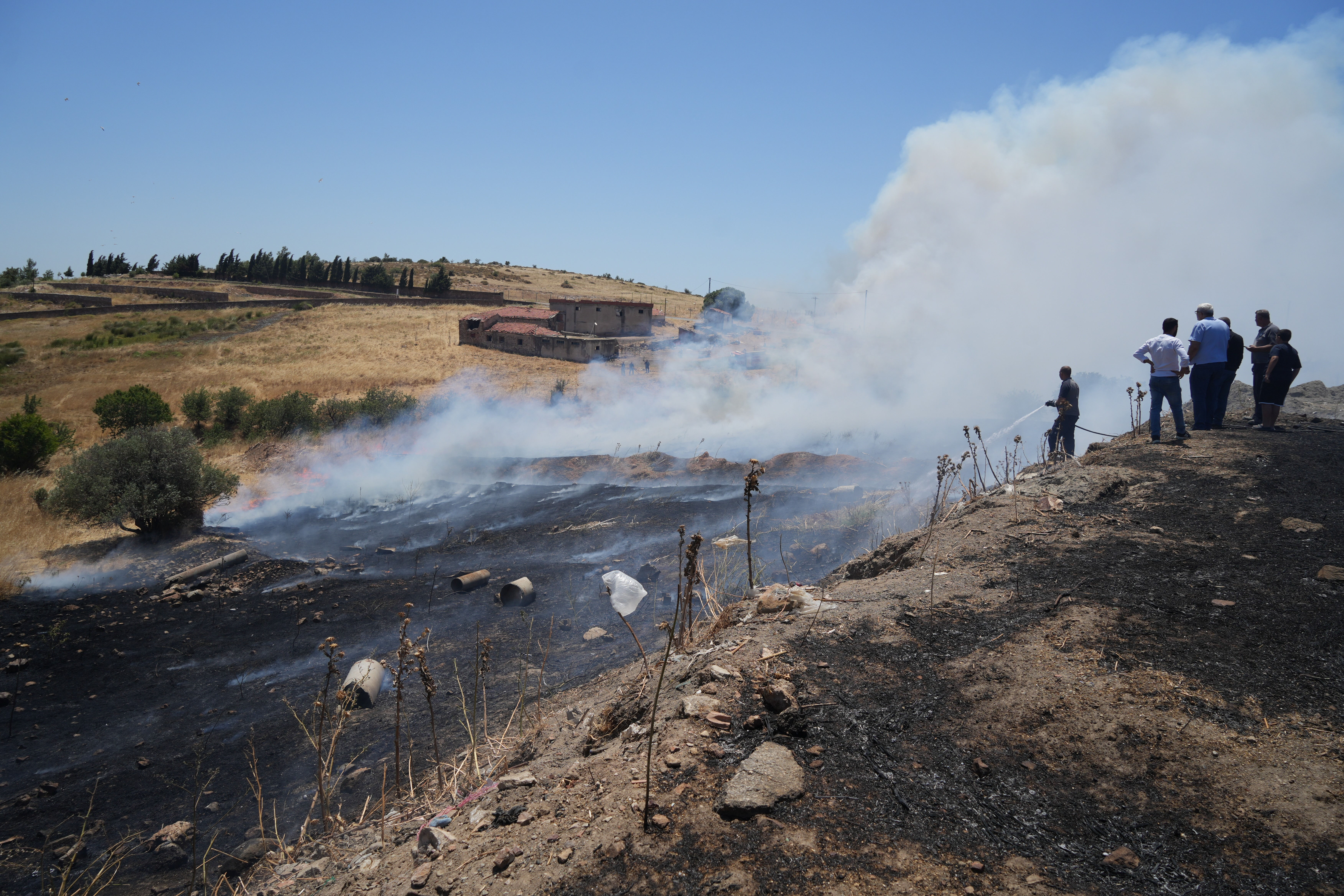 Balıkesir'in Ayvalık ilçesinde makilik alana sıçrayan yangını söndürme çalışmaları devam ediyor - 1. Resim