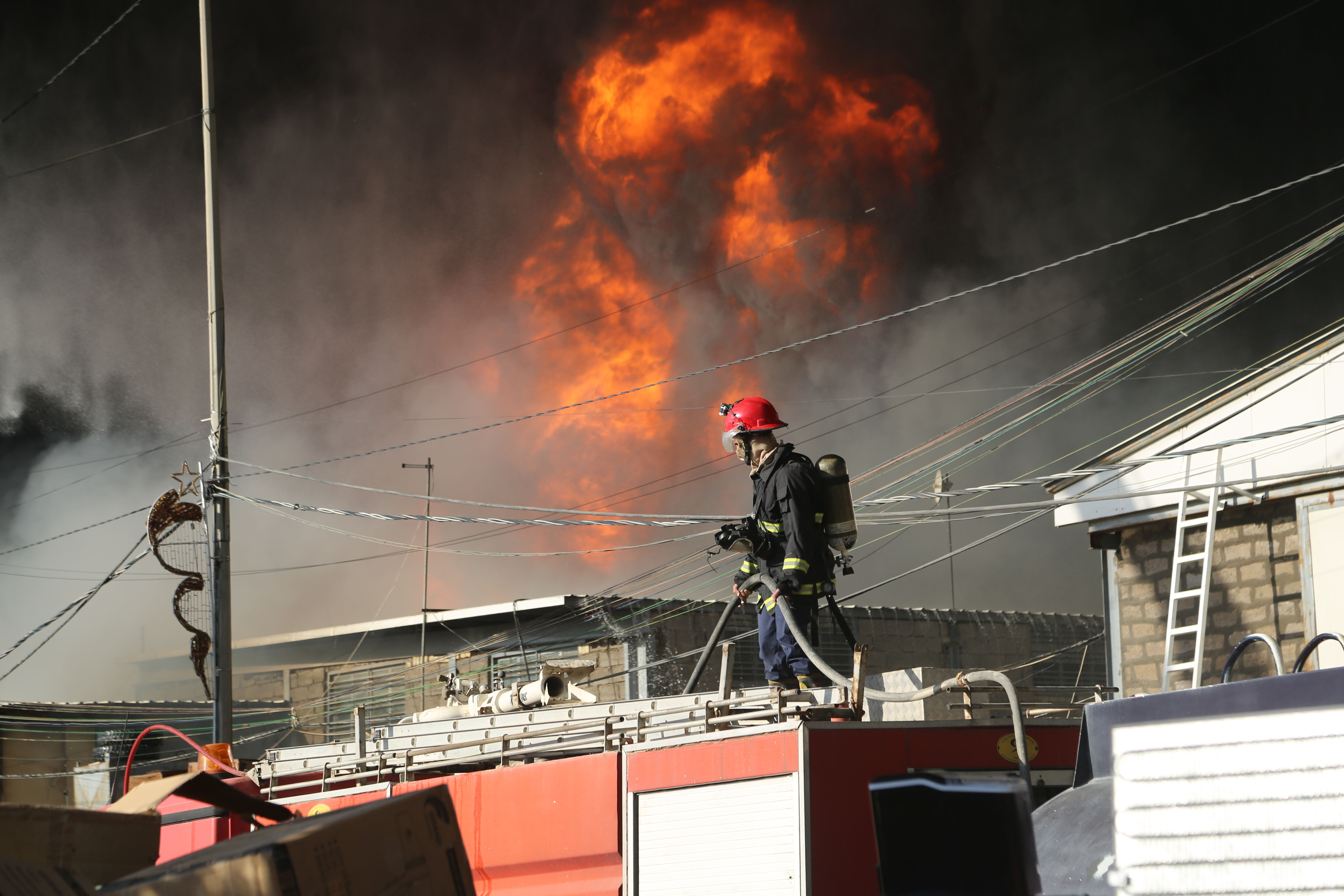 Irak'ın başkenti Bağdat'ta bir depodan yangın çıktı, gökyüzünü kapkara dumanlar kapladı - 1. Resim