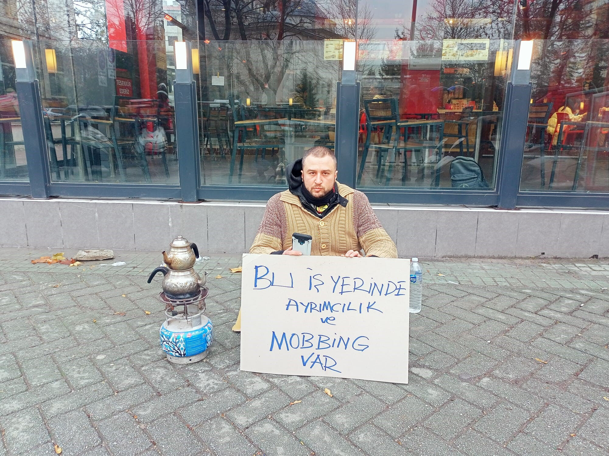 Eşine haksızlık yapıldığını söyleyen koca işletme önünce oturma eylemi başlattı - 1. Resim