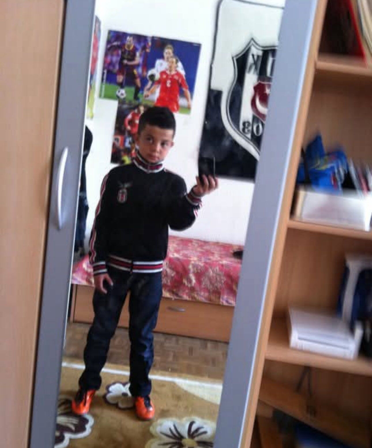 Zeki Amdouni takes a mirror selfie in his childhood room filled with Besiktas-branded items. (Türkiye Daily)