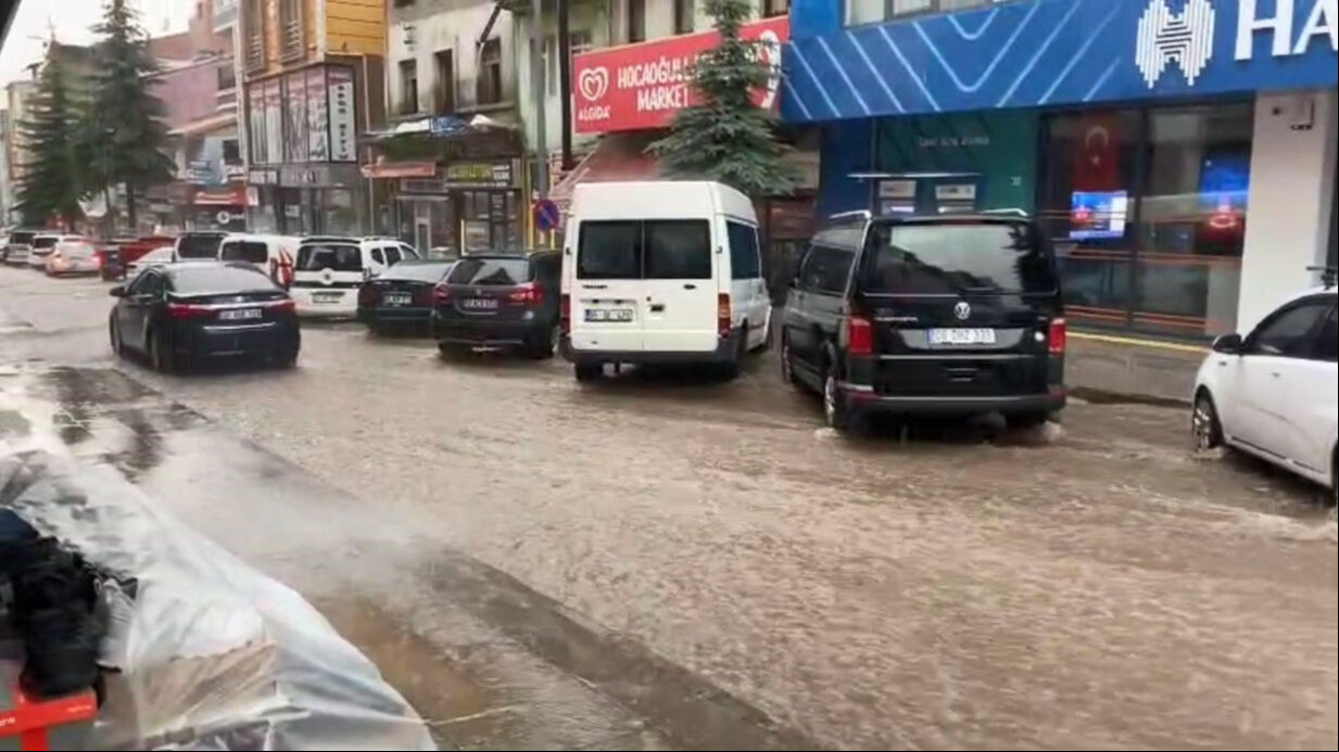O ilçede sıcak hava bir anda yerini yağışa bıraktı! Sokaklar göle döndü, iş yerlerini su bastı - 1. Resim