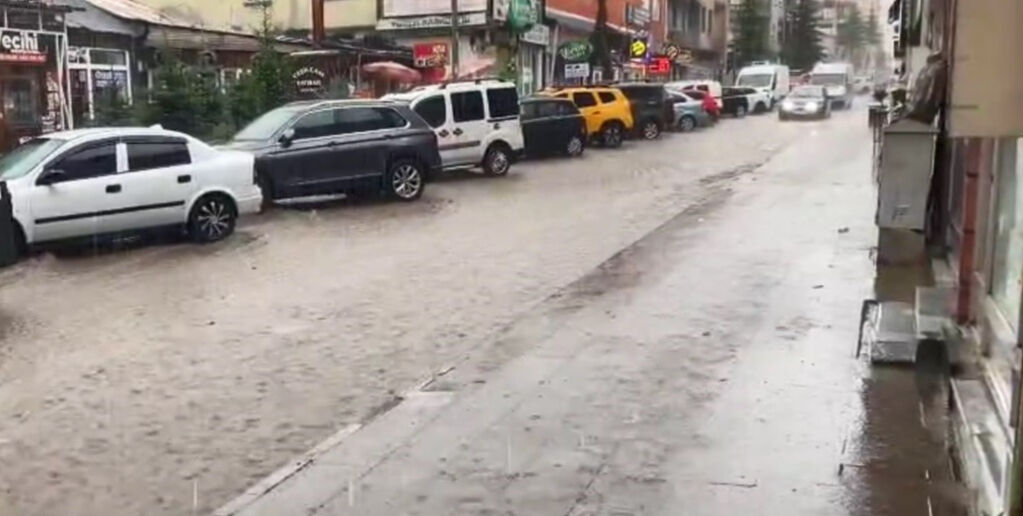 O ilçede sıcak hava bir anda yerini yağışa bıraktı! Sokaklar göle döndü, iş yerlerini su bastı - 2. Resim