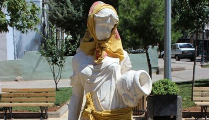 Kız heykelin başına örtü beline şal taktılar