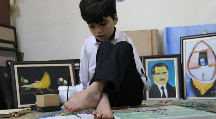 Ayağıyla çizdiği resimleri satarak aile bütçesine katkı sağlıyor Ayağıyla çizdiği resimleri satarak aile bütçesine katkı sağlıyor