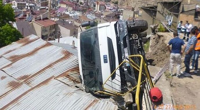 Kamyon evin çatısına devrildi Kamyon evin çatısına devrildi