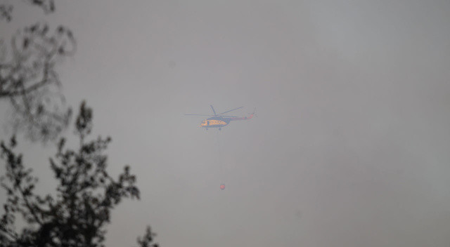 Uçak ve helikopterler sık sık yoğun dumanlık alanlara sorti yaparak yangının önünü kesmeye çalışıyor.