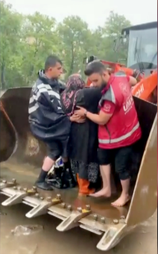 Kurtarma görevlisi selde mahsur kalan kadına kendi çizmelerini verdi Kurtarma görevlisi selde mahsur kalan kadına kendi çizmelerini verdi
