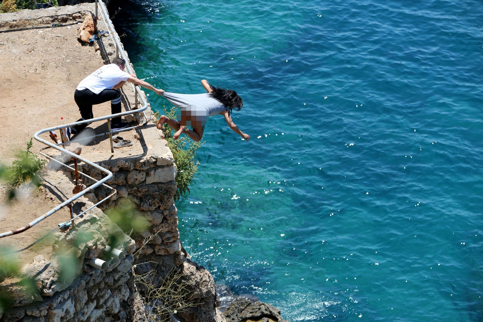 Genç kız herkesin gözleri önünde falezlerden atladı!