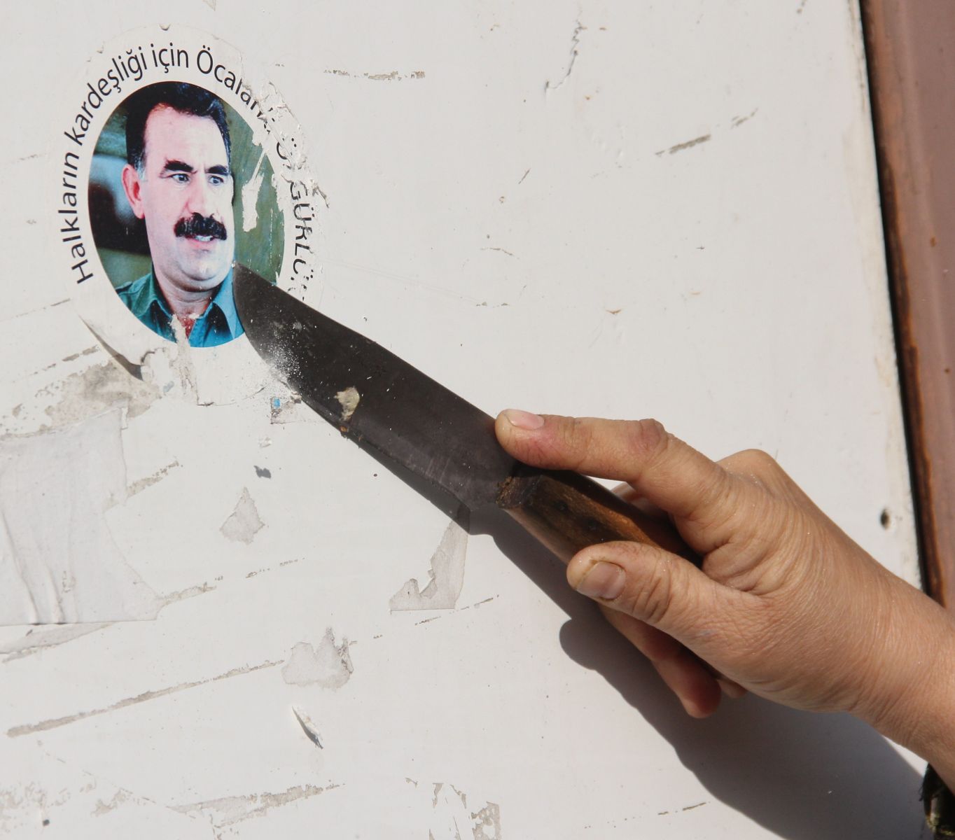 Polisi gören kadın Öcalan çıkarmasını bıçakla kazıdı