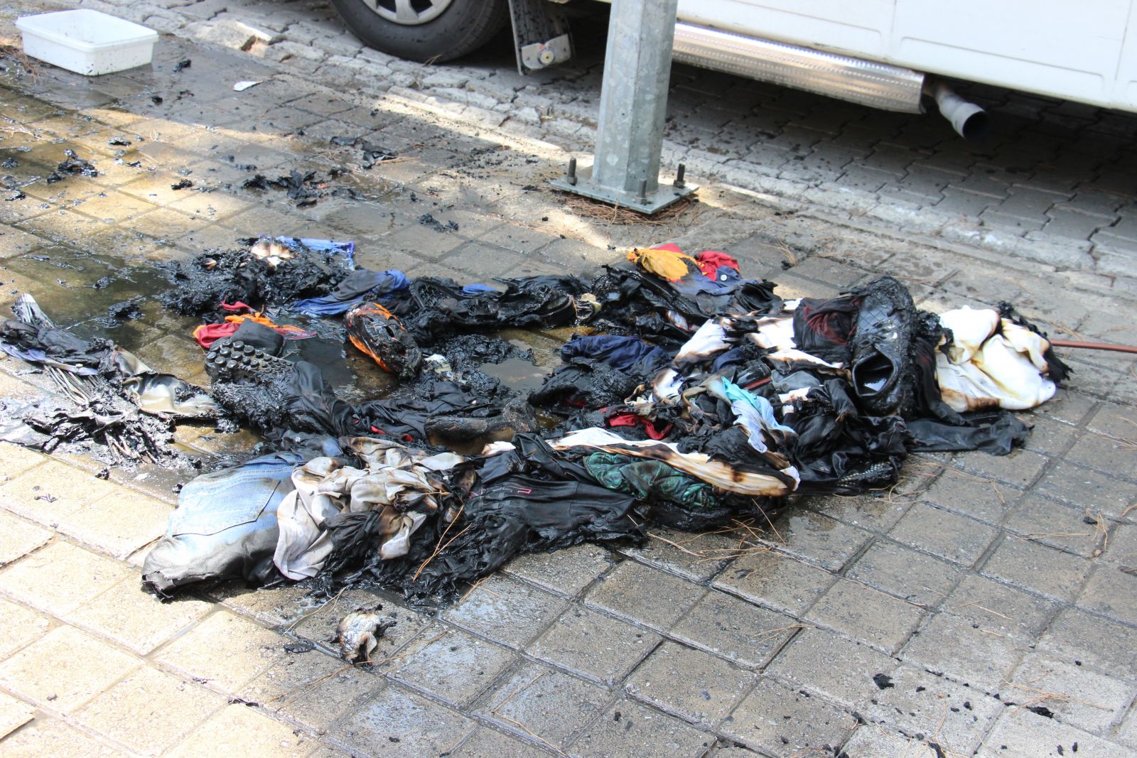 Elbiselerini sokağa döküp ateşe verdi