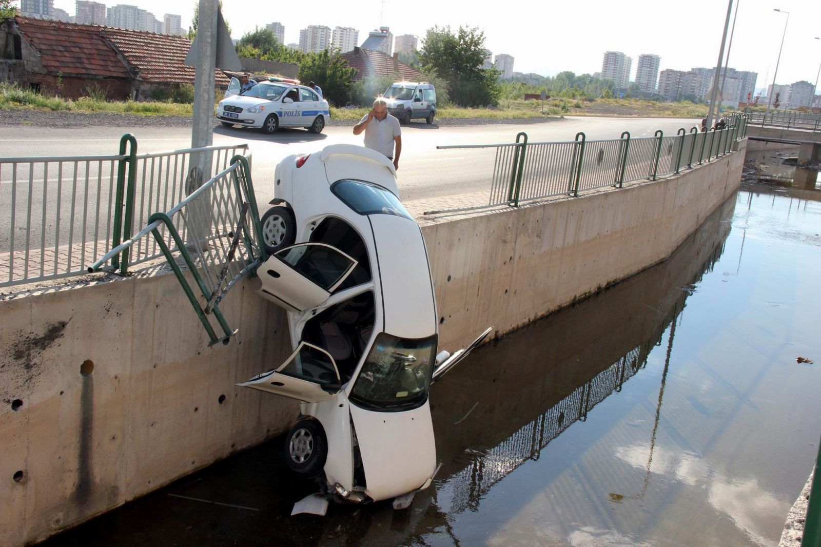 Su kanalına düşen araba asılı kaldı