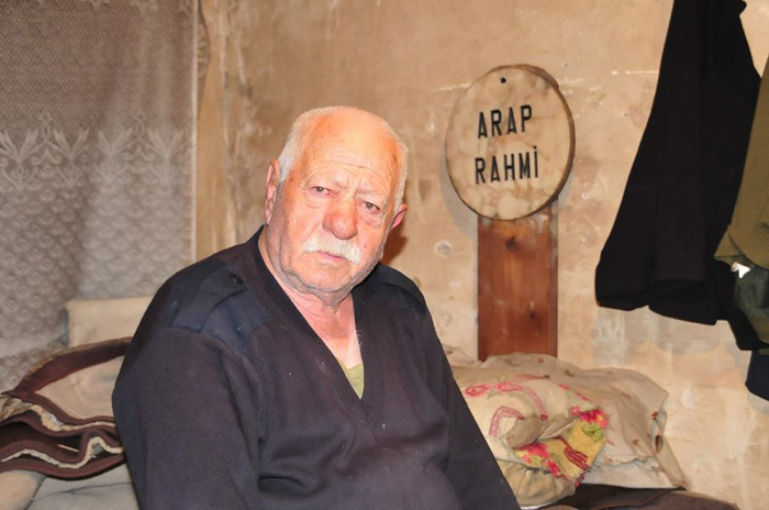 Mezar tahtası başucunda uyuyor