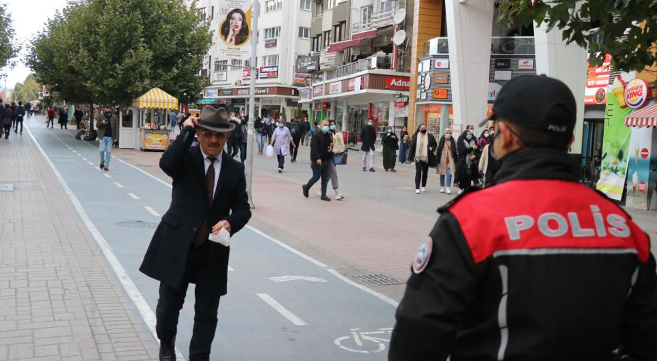 Polisi gören maskesiz vatandaş şapkasının arkasına saklandı