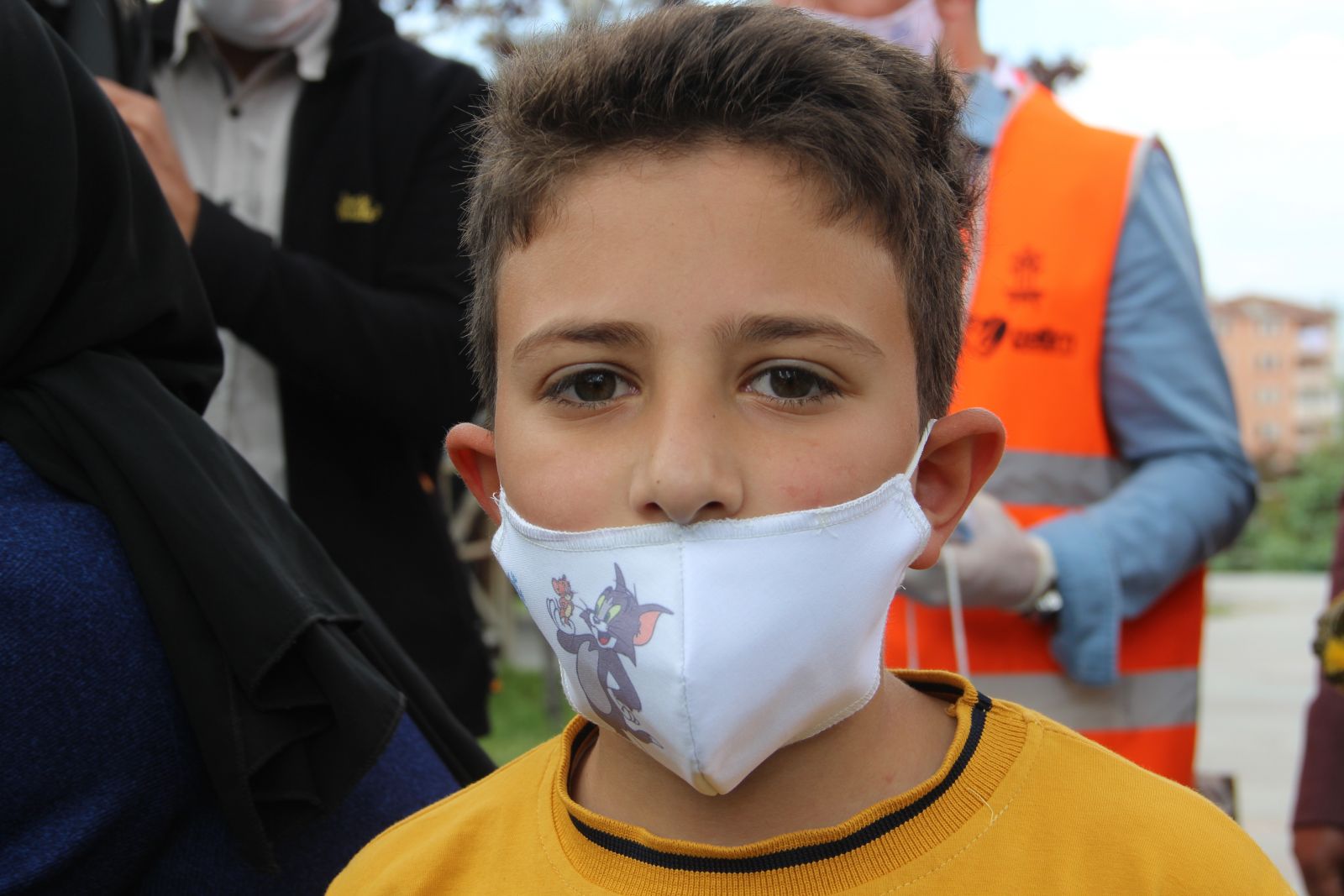 Çocuklar bu maskeleri takmak için sıraya giriyor