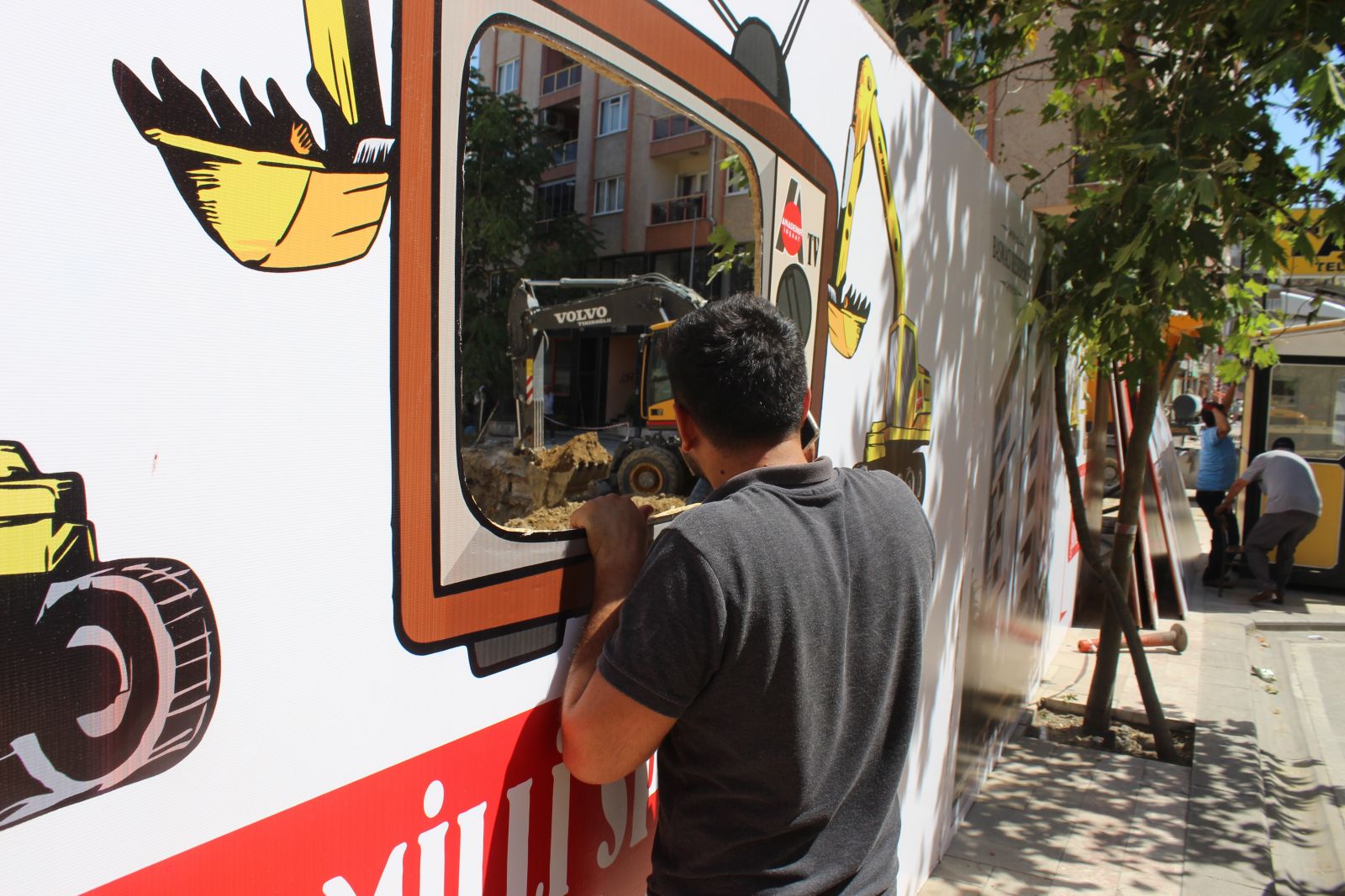 Vatandaşlar inşaat çalışmalarını televizyon şeklinde pencereden izliyor