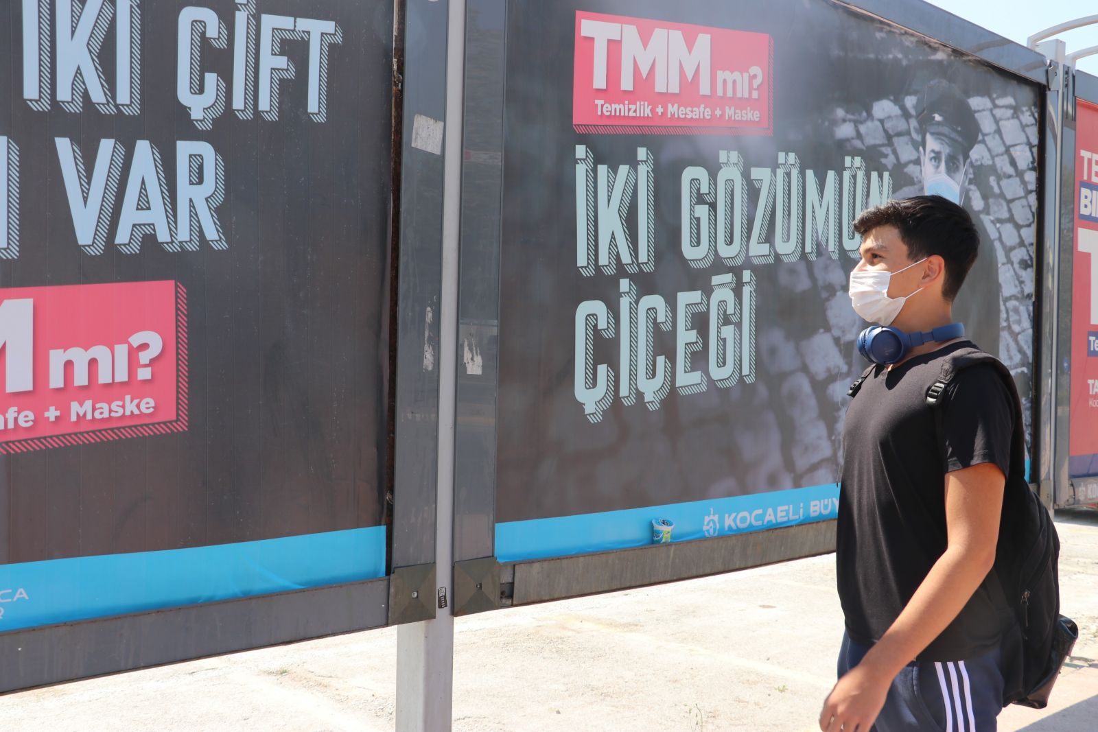 Yeşilçam'ın unutulmaz isimlerinin yer aldığı afişleri gören maskesini takıyor