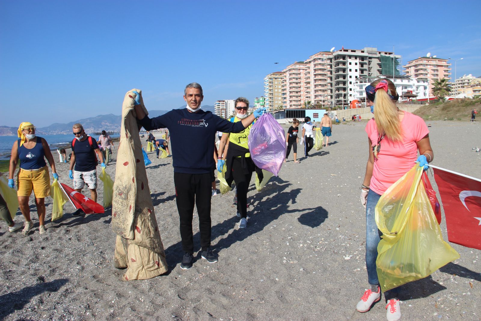 Alanya'da yaşayan yabancılar bu defa mayoları ile değil çöp torbalarıyla sahile akın ettiler