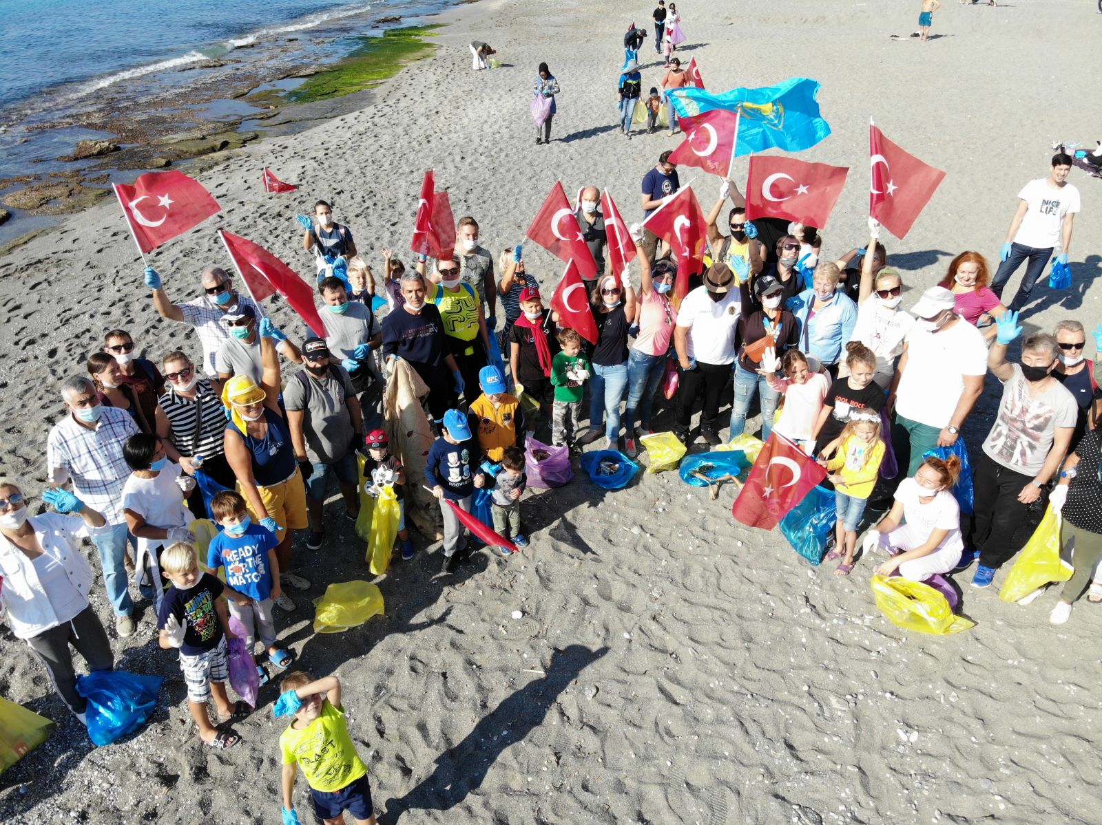 Alanya'da yaşayan yabancılar bu defa mayoları ile değil çöp torbalarıyla sahile akın ettiler