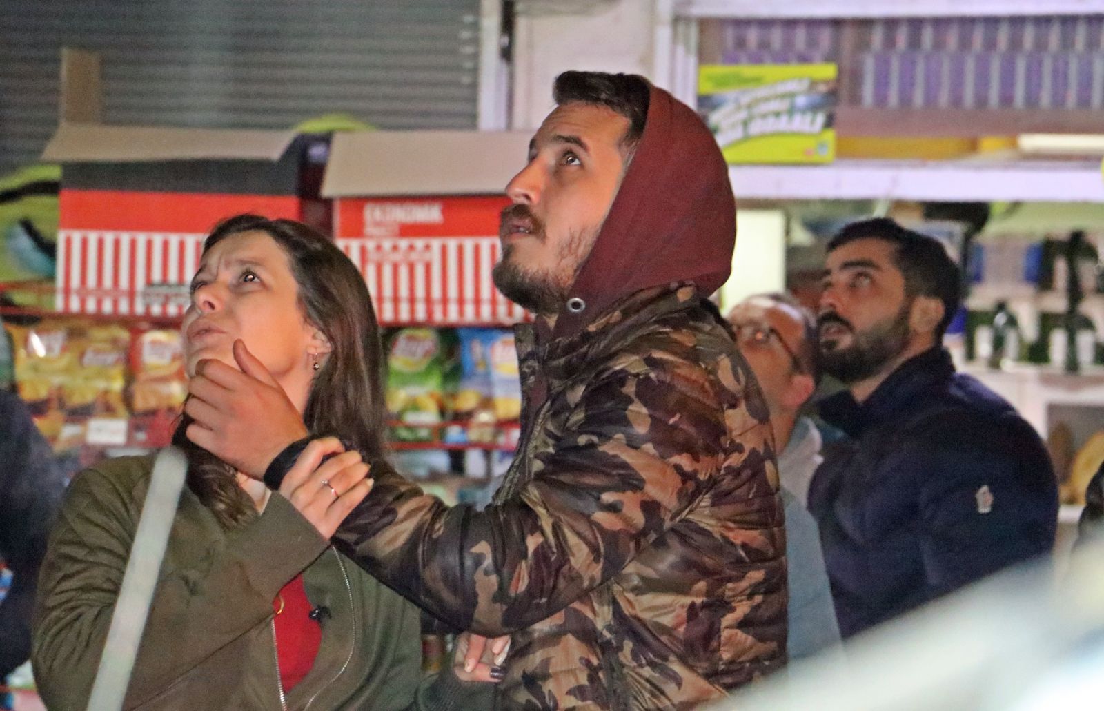 Apartmanın çatısından aşağı sarkan kadını cips yiyerek izlediler