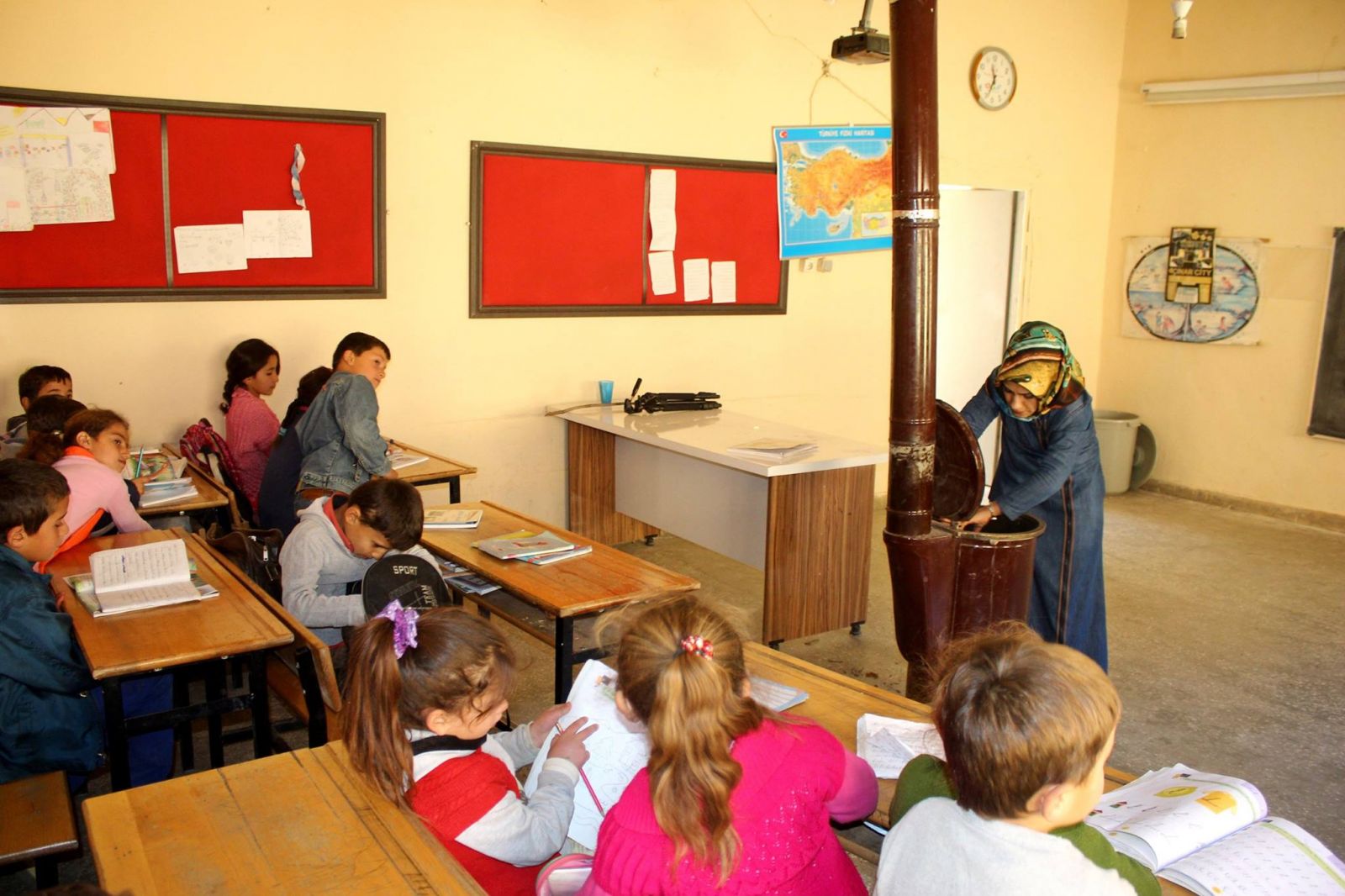 Ayşe öğretmen odun topluyor, sobayı yakıyor, sınıfları temizliyor