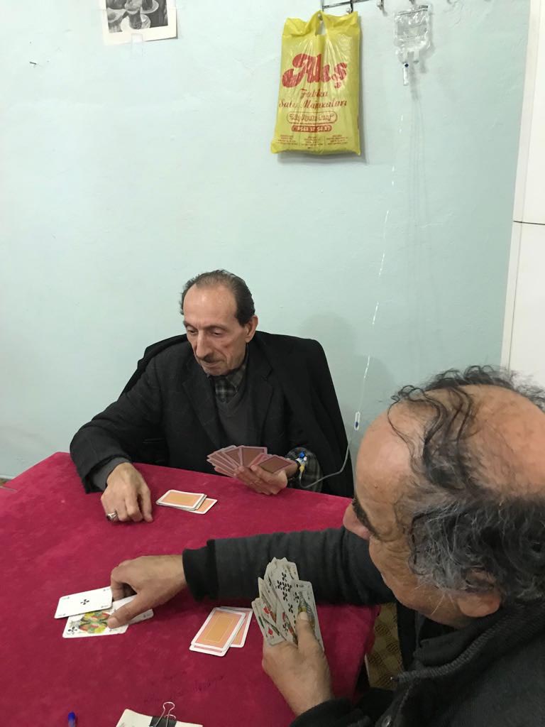 Kolunda serumla kahvede kağıt oynadı