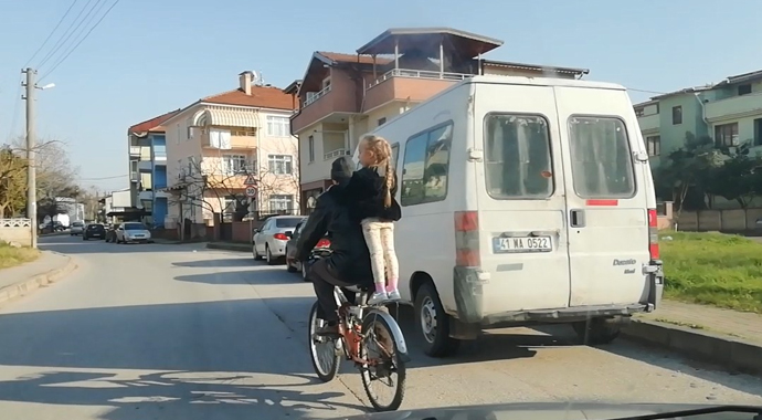 Küçük çocuğun bisiklet selesinde ayakta tehlikeli yolculuğu