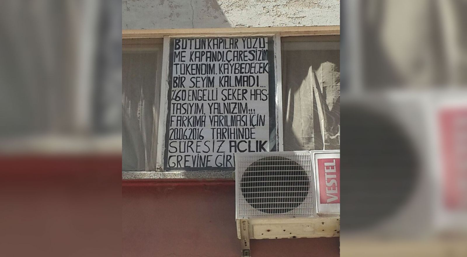 İş bulamayan engelli, evin penceresine pankart asıp greve girdi