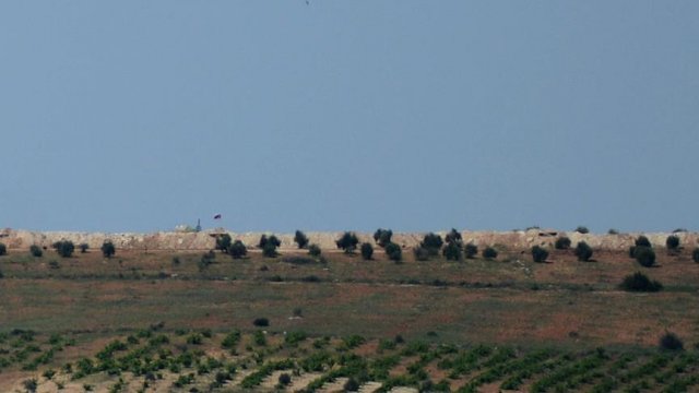 PYD'nin sınıra çektiği Suriye ve Rus bayrakları silahlı kişilerce korunuyor PYD'nin sınıra çektiği Suriye ve Rus bayrakları silahlı kişilerce korunuyor