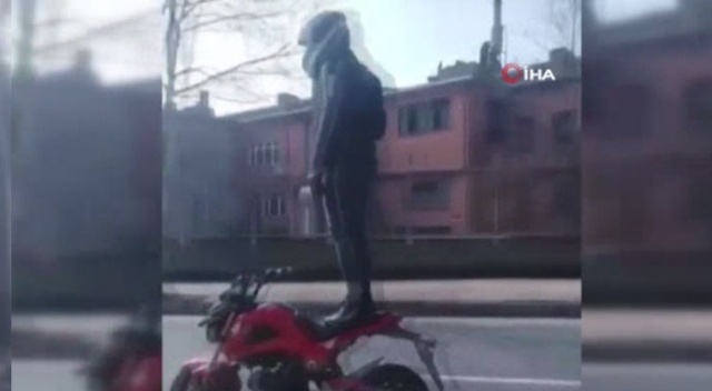 Trafikte motosiklet üzerinde ayağa kalkan sürücü kamerada