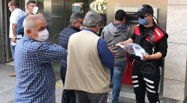 Adana'da polis, banka önlerinde sıra bekleyenlere maske dağıttı