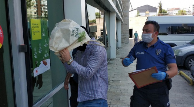 AVM'den hırsızlık zanlısı, adliyeye çıkarılırken tanınmamak için kafasına bez çanta geçirdi