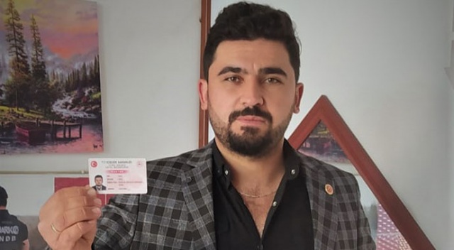 Muhtar olduğuna inandırmak için kimliğini gösteriyor