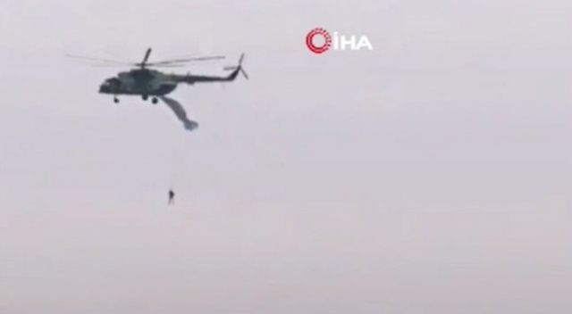 Askeri helikoptere takılan paraşütçü havada asılı kaldı