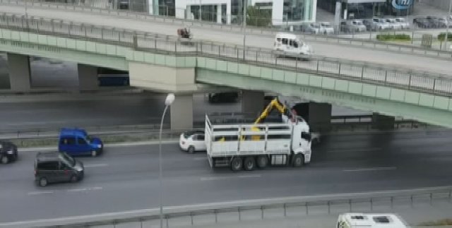 İş makinesi taşıyan kamyon köprüye takıldı